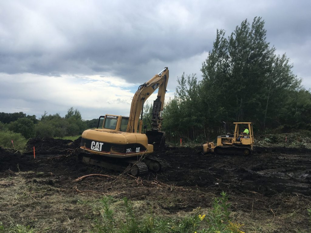 Preparing the site for a flow-over ditch plug. Clearing sod and debris ensures the ditch plug is built on a solid base and is able to hold back water.