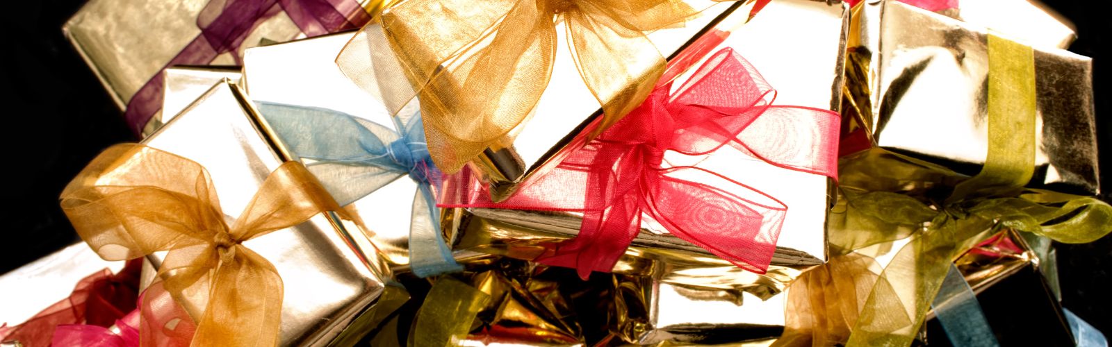 Gifts wrapped in gold paper with different colored ribbons