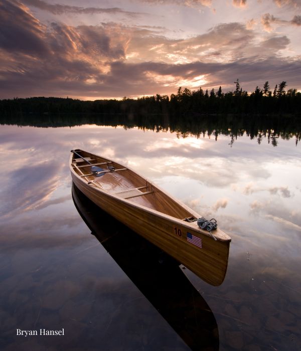 Wooden canoe in a lake at sunset
