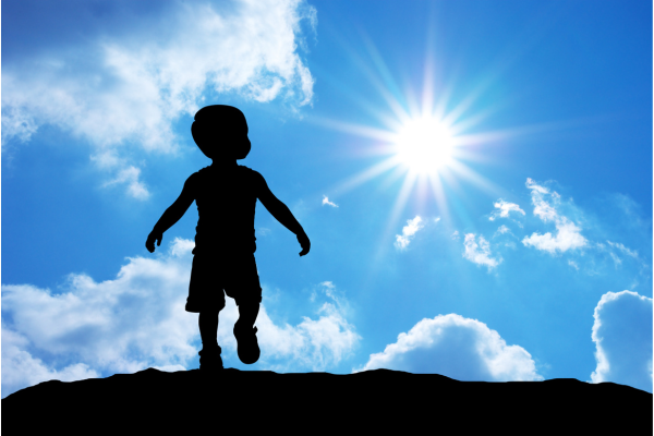 Child's silhouette against a blue sky background